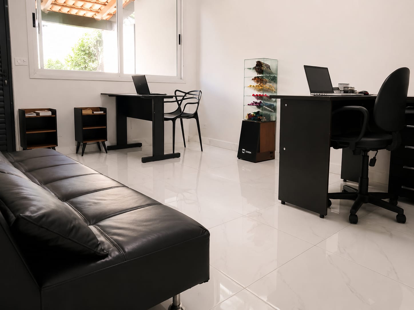 Sala de atendimento com mesas, poltrona e ambiente claro
